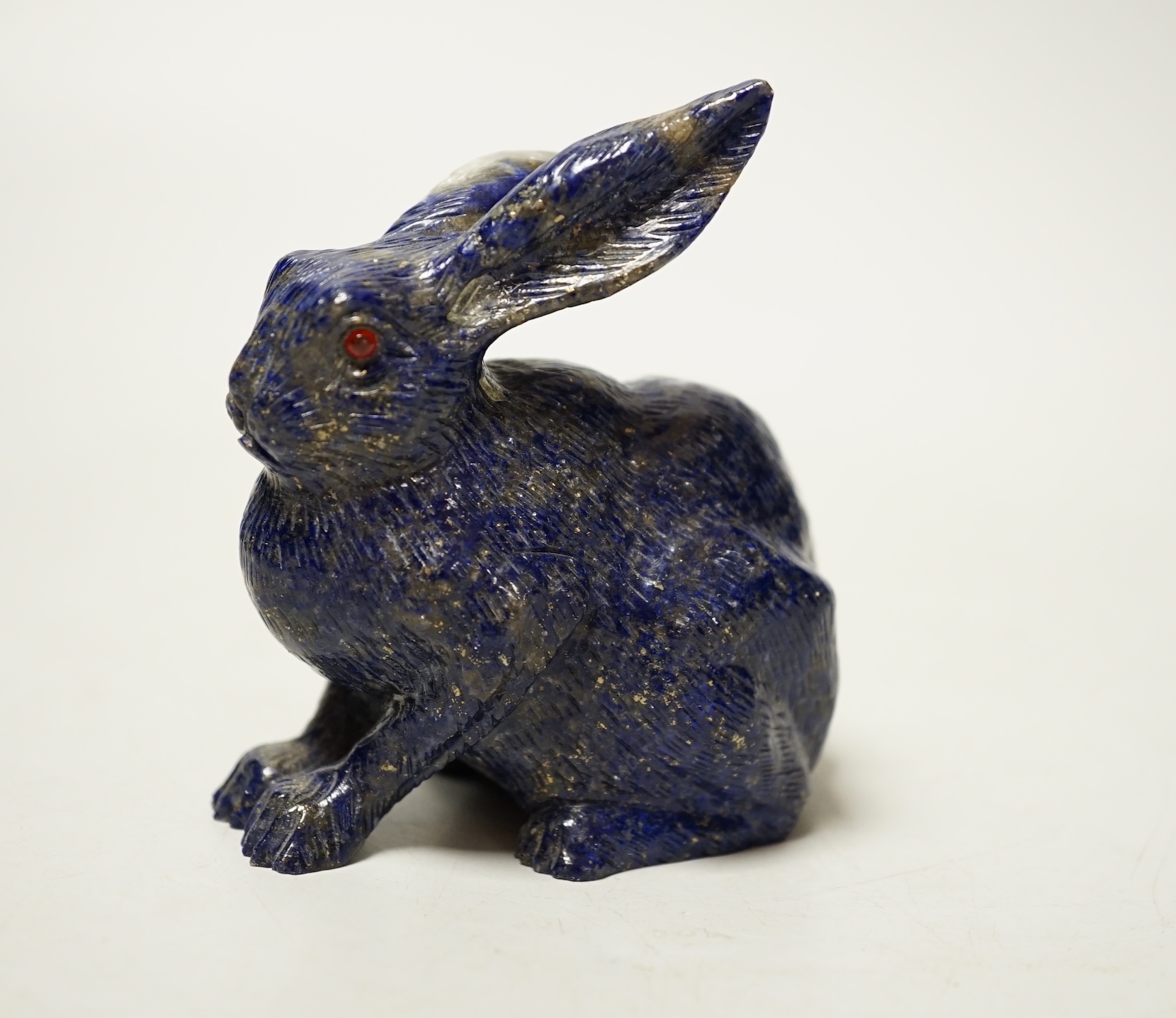A Chinese lapis lazuli model of a hare, with glass inset eyes, 8.4cm high